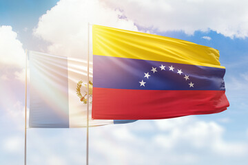 Sunny blue sky and flags of venezuela and guatemala