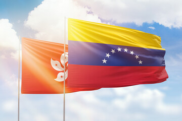 Sunny blue sky and flags of venezuela and hong kong