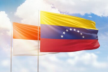 Sunny blue sky and flags of venezuela and indonesia