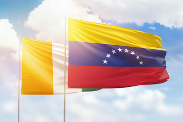 Sunny blue sky and flags of venezuela and ivory coast