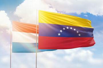 Sunny blue sky and flags of venezuela and luxembourg