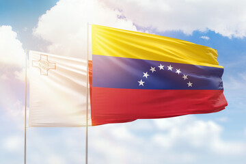 Sunny blue sky and flags of venezuela and malta