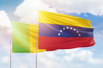 Sunny blue sky and flags of venezuela and mali