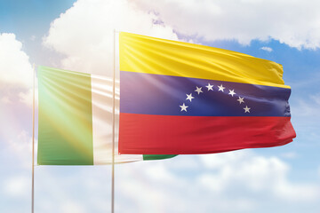 Sunny blue sky and flags of venezuela and nigeria