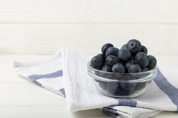 Blueberries in a bowl on a white textured background. Ripe and fresh blueberries. vitamins. Health food. Juicy berry. Copy space. Place for text