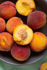 Fototapeta na wymiar Overhead view of ripe organic peach in gray bowl fruits