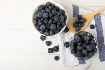 Blueberries in a bowl on a white textured background. Ripe and fresh blueberries. vitamins. Health food. Juicy berry. Copy space. Place for text