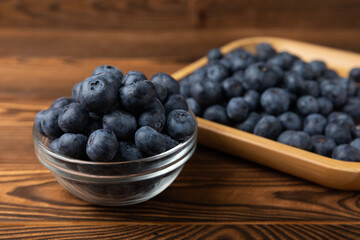 Blueberries in a bowl on a brown textured background. Ripe and fresh blueberries. vitamins. Health food. Juicy berry. Copy space. Place for text
