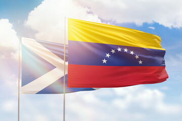 Sunny blue sky and flags of venezuela and scotland