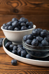 Blueberries in a bowl on a brown textured background. Ripe and fresh blueberries. vitamins. Health food. Juicy berry. Copy space. Place for text