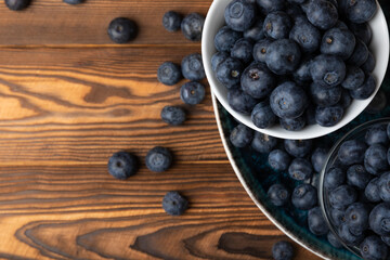 Blueberries in a bowl on a brown textured background. Ripe and fresh blueberries. vitamins. Health food. Juicy berry. Copy space. Place for text