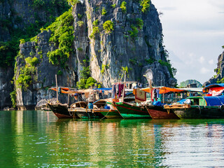 Obraz premium Multicolored fishing boats reflected in the emerald waters of Ha Long bay, Vietnam 