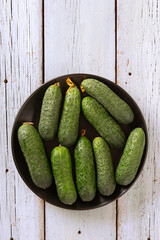 Fresh cucumbers from the garden on a light wooden background, natural eco food