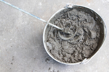 Mixing of concrete mortar.The builder prepares the cement mortar using a construction mixer.Plaster mortar in a bucket