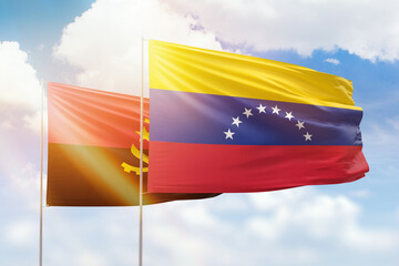 Sunny blue sky and flags of venezuela and angola