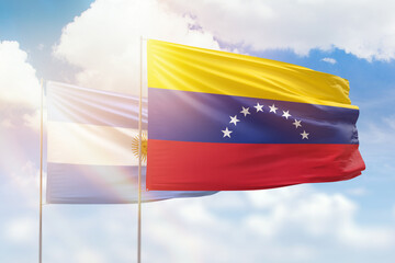 Sunny blue sky and flags of venezuela and argentina