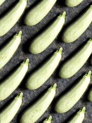 A pattern of young, tender zucchini on a black concrete background. Background of fresh summer vegetables.