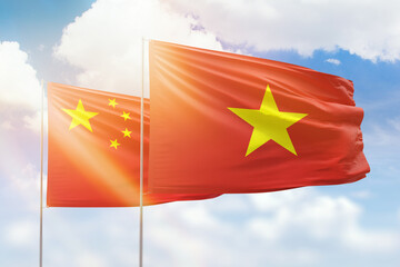 Sunny blue sky and flags of vietnam and china