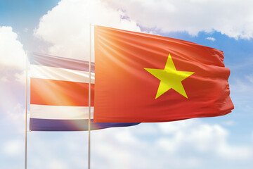 Sunny blue sky and flags of vietnam and costa rica