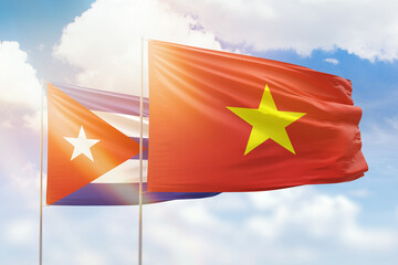 Sunny blue sky and flags of vietnam and cuba