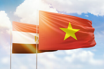 Sunny blue sky and flags of vietnam and egypt