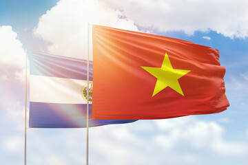 Sunny blue sky and flags of vietnam and el salvador