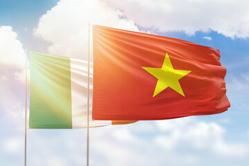 Sunny blue sky and flags of vietnam and ireland