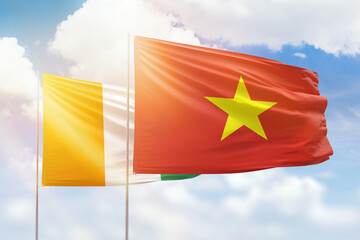 Sunny blue sky and flags of vietnam and ivory coast