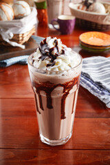 A glass of healthy fresh mocha frappe isolated on wooden background side view