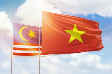 Sunny blue sky and flags of vietnam and malaysia