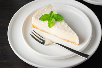 Cheesecake in a plate on a dark wooden table - obrazy, fototapety, plakaty