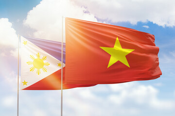 Sunny blue sky and flags of vietnam and philippines