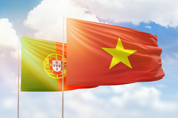 Sunny blue sky and flags of vietnam and portugal