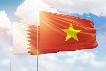 Sunny blue sky and flags of vietnam and qatar