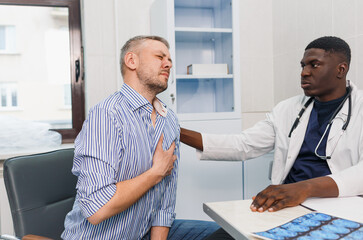 a patient experiences heart pain at an appointment with an African-American doctor.