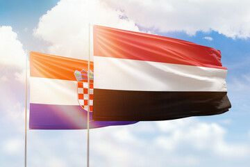 Sunny blue sky and flags of yemen and croatia