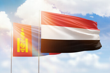 Sunny blue sky and flags of yemen and mongolia