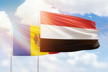 Sunny blue sky and flags of yemen and moldova