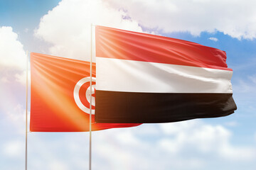 Sunny blue sky and flags of yemen and tunisia