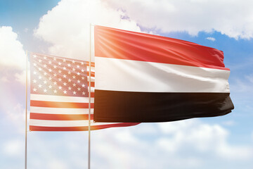 Sunny blue sky and flags of yemen and usa