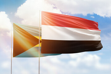 Sunny blue sky and flags of yemen and bahamas