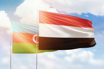 Sunny blue sky and flags of yemen and azerbaijan