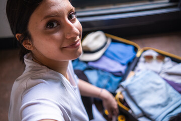 young and modern woman packing suitcase, shooting selfie,  young and modern woman packing suitcase