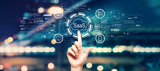 SaaS - software as a service concept with hand pressing a button on a technology screen