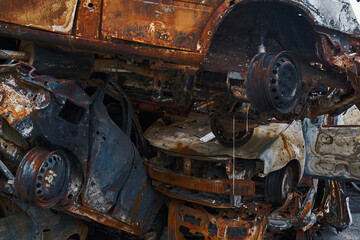 Fototapeta premium Burned vehicles put on one another after bombardment in Irpin