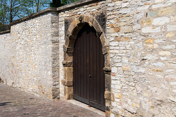 Fototapeta na wymiar Antique wooden gate in a stone wall.