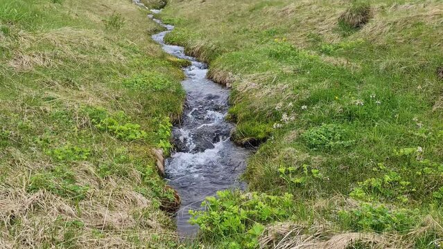 Fantastic landscape with flowing rivers and streams with rocks and grass in Iceland.