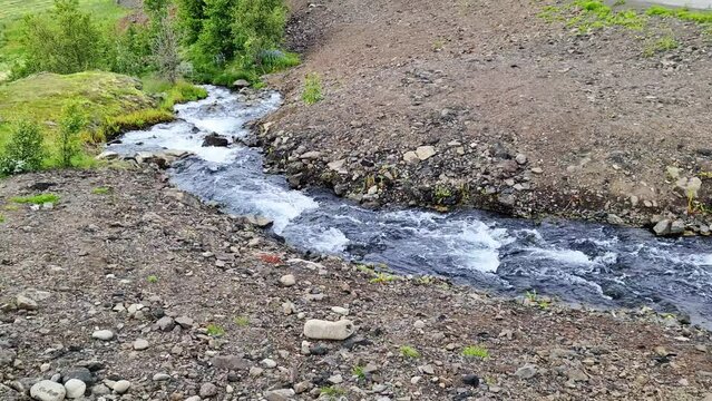 Fantastic landscape with flowing rivers and streams with rocks and grass in Iceland.