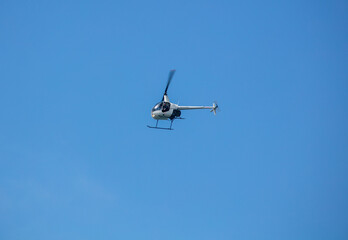A Small Helicopter flying in a Blue Sky