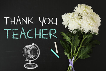 Phrase Thank You Teacher, beautiful flowers and chalk on blackboard, flat lay